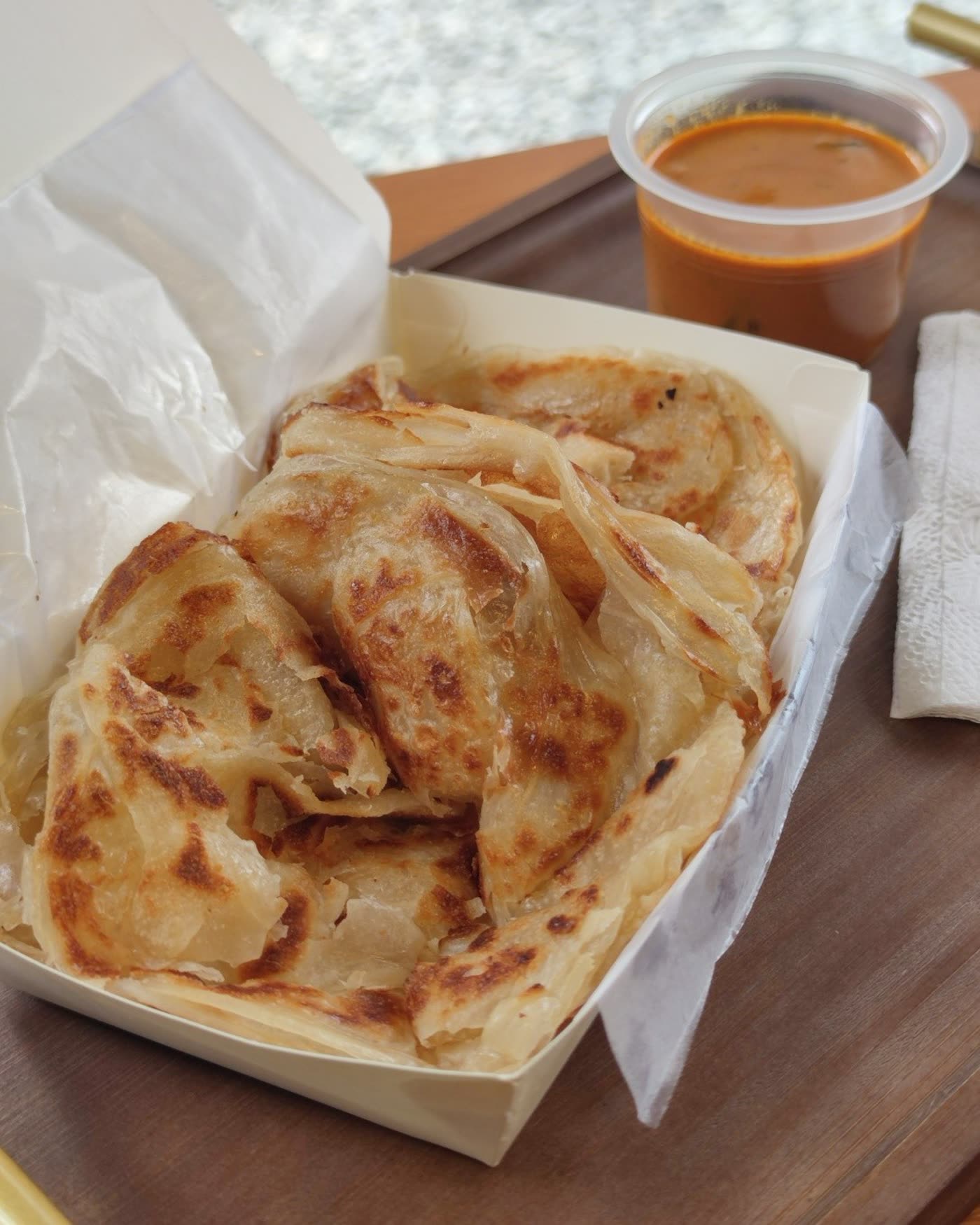 Roti canai with a cup of curry